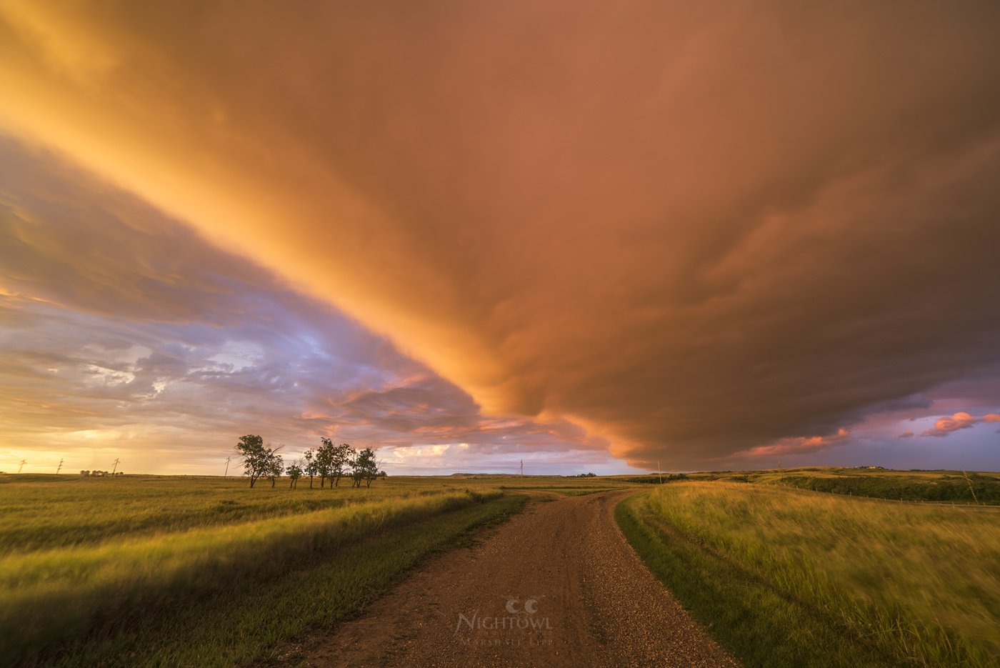 A storm-lit road across the prairie