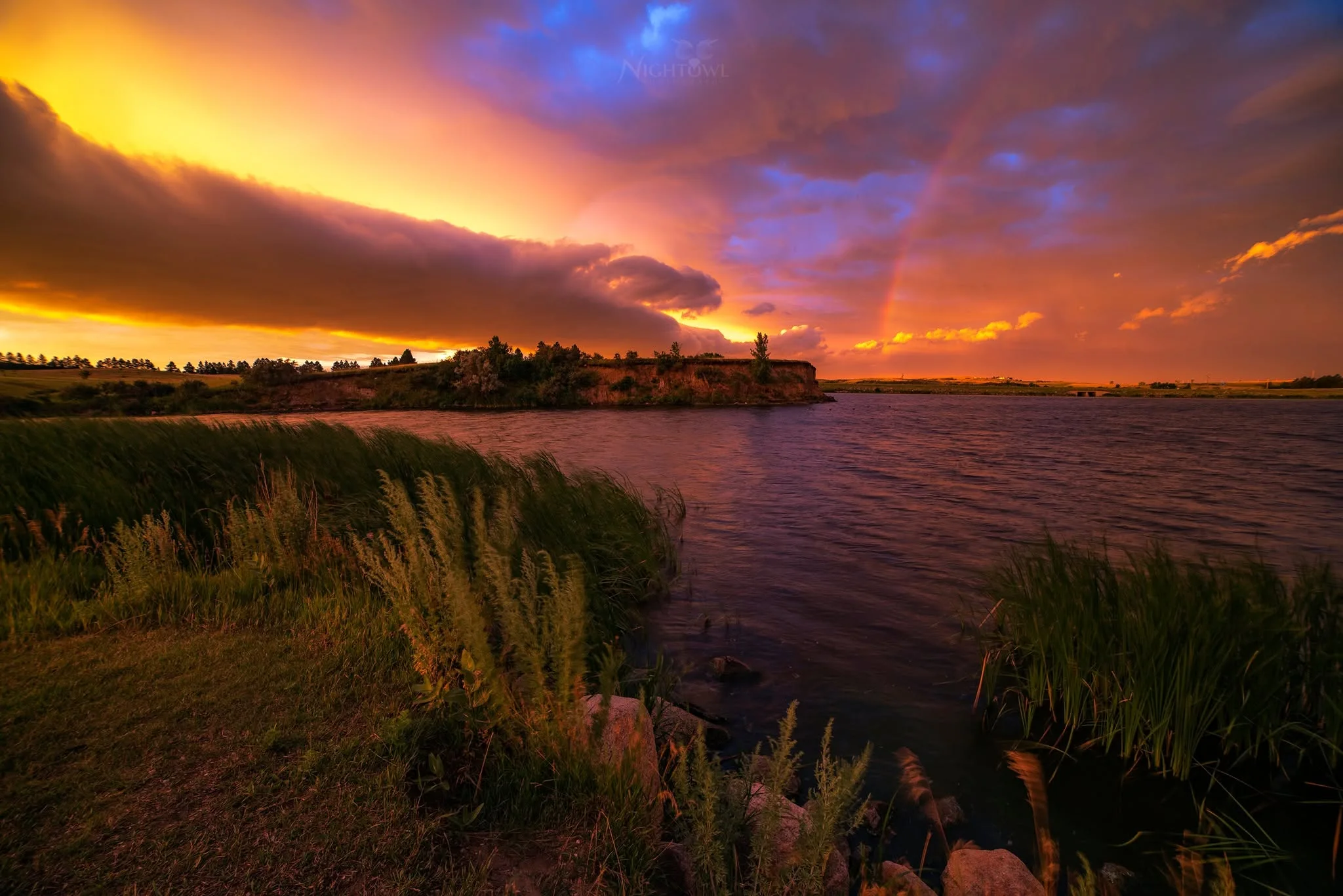 Storm light and a rainbow over the lake